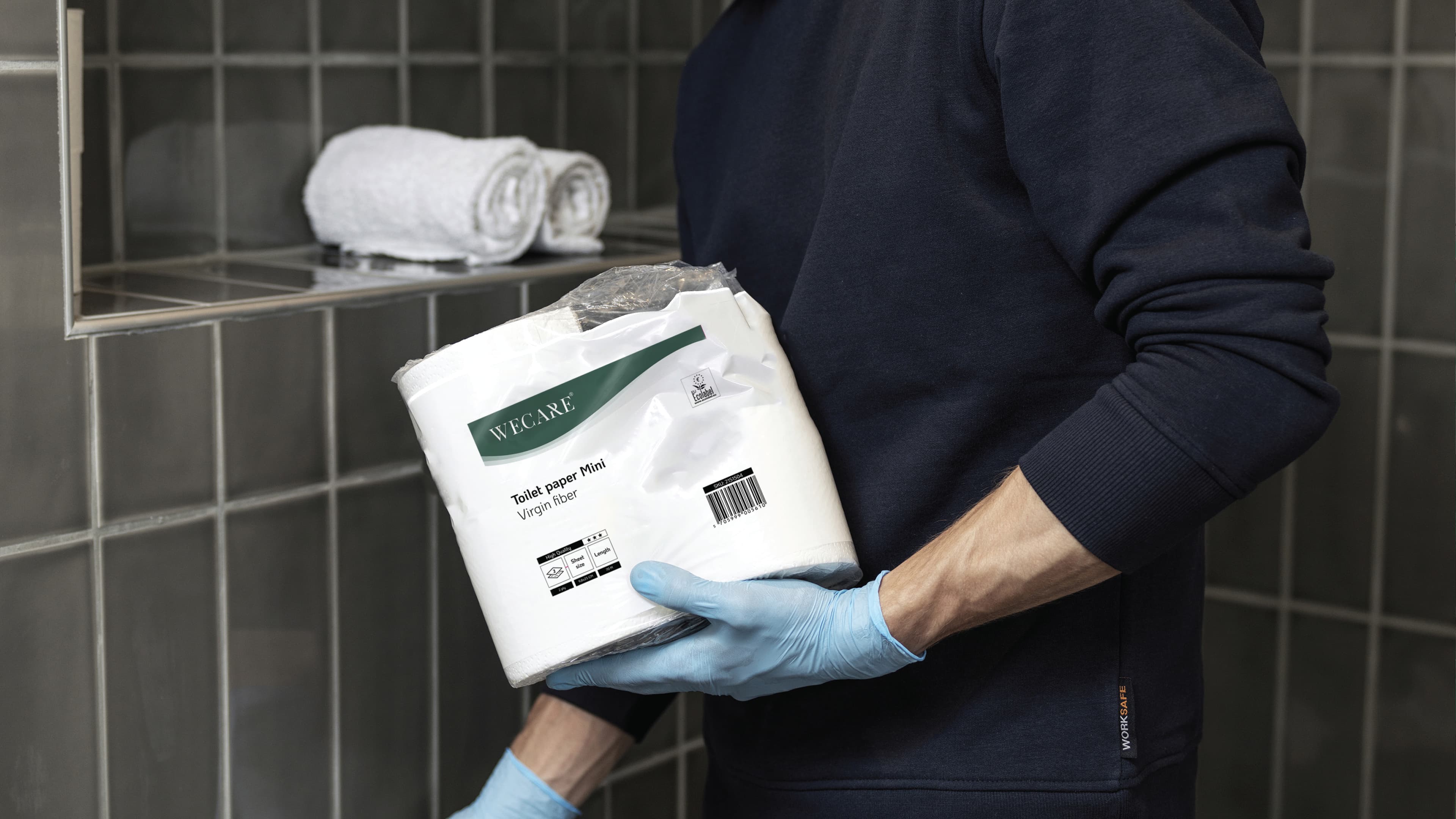 En person håller en förpackning med Wecare toalettpapper