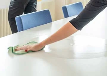 Person torkar av bord med mikrofiberduk